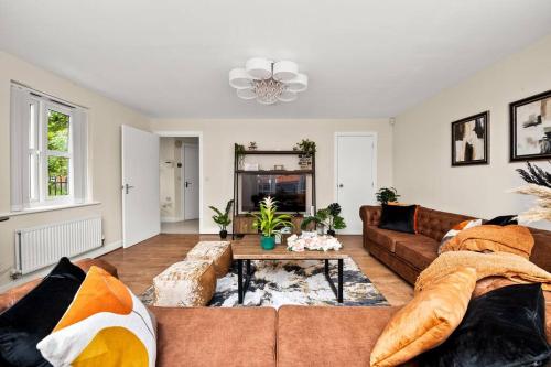 a living room with a couch and a table at Radiant Retreat Ideal for LegoLand, Windsor, & LHR in Slough