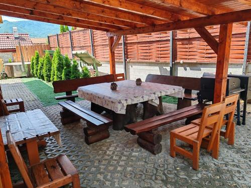 a patio with a table and benches and a television at Kanadský zrub in Prievidza