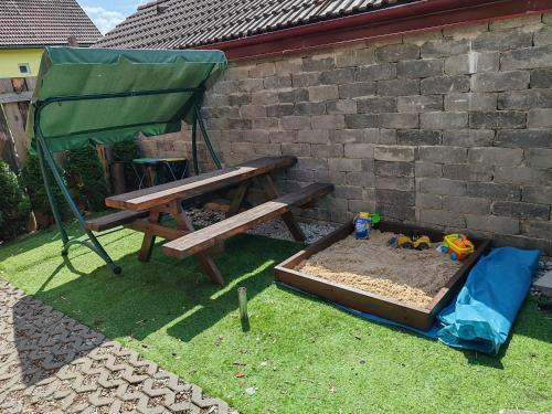 a sandbox with a picnic table and a bench at Kanadský zrub in Prievidza