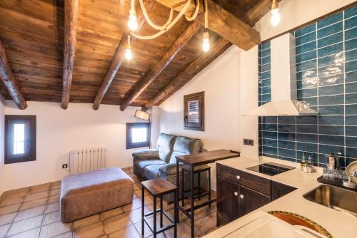 a kitchen and living room with wooden ceilings at La Botica in Albarracín