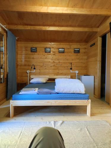 a bed in a room with a wooden wall at Parque de Campismo de Fão in Fão