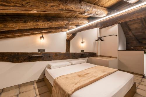 a bedroom with two beds and wooden ceilings at La Botica in Albarracín