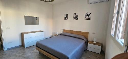 a bedroom with a bed and two pictures on the wall at Residenza il Filo in Orosei