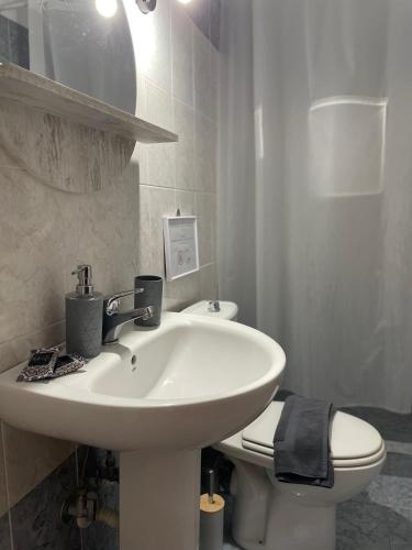 a white bathroom with a sink and a toilet at Melivia apartments (2) in Ierissos