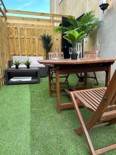 d'une terrasse avec une table en bois et de la pelouse verte. dans l'établissement Marbella Logement privatif -Jacuzzi-Sauna, à La Valette-du-Var