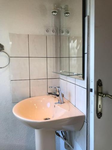 une salle de bain avec un lavabo et un miroir dans l'établissement Logis cosy, à Montbéliard