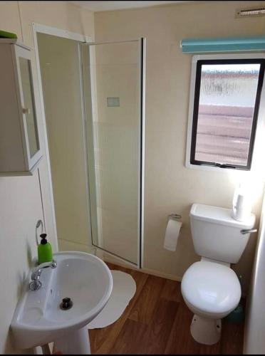 a bathroom with a white toilet and a sink at Superdomkikarwia in Karwieńskie Błoto Pierwsze
