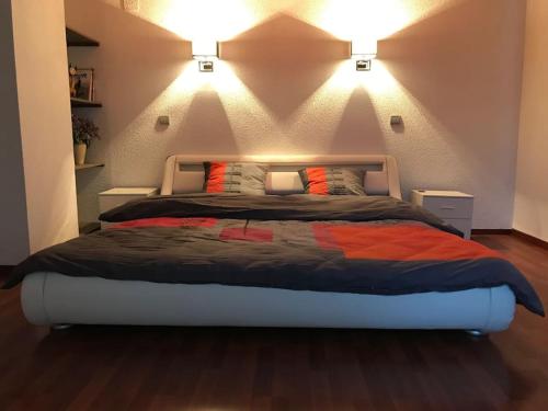- une chambre dotée d'un grand lit avec deux lumières dans l'établissement Logis cosy, à Montbéliard