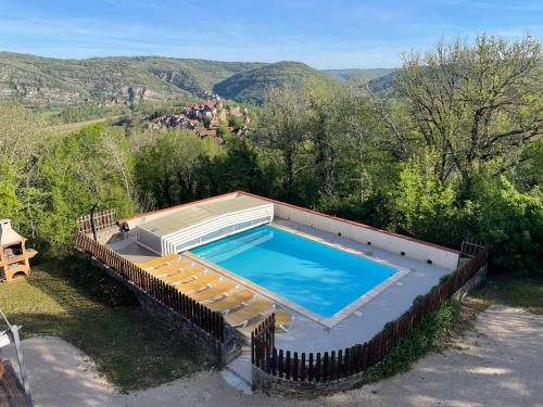 - une vue sur la piscine et ses chaises longues dans l'établissement Gîte vue imprenable Vallée du Lot, piscine privée, à Calvignac