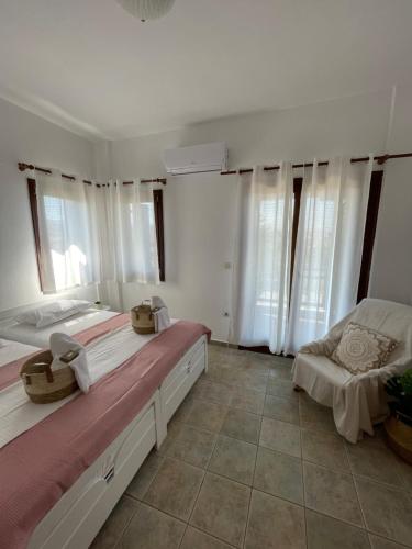 two beds in a room with white walls and windows at Melivia apartments (2) in Ierissos