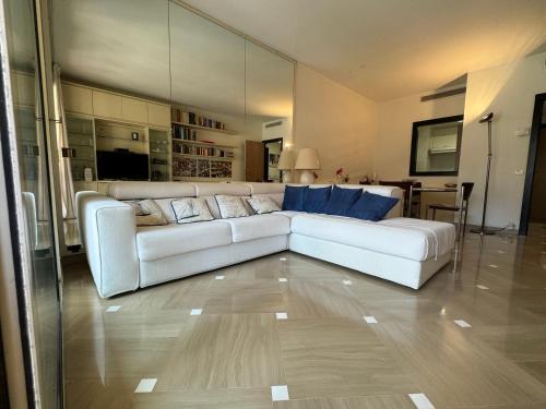 uma sala de estar com um sofá branco e uma cozinha em Elegant Monaco Port de Fontvieille apartment with Garden View and Pool Access em Monte Carlo