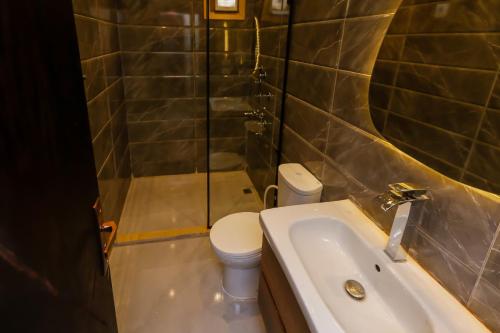 a bathroom with a toilet and a sink and a shower at Crowne Pyramids View inn in Cairo