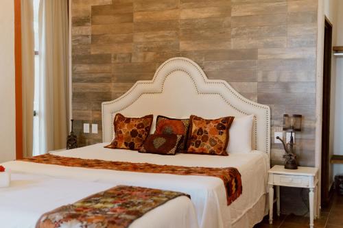 a bedroom with a large white bed with pillows at Hacienda San Nicolas de las Fuentes in Teuchitlán