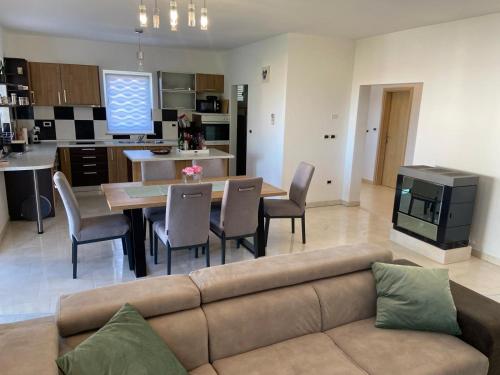 a living room and kitchen with a couch and a table at Holiday Home Mihaela in Višnjan