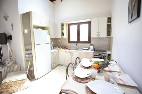kuchnia ze stołem i białą lodówką w obiekcie Kores Villas w mieście Nydri
