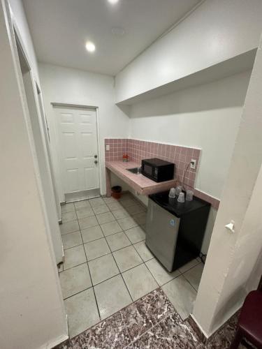 a small kitchen with a counter and a microwave at Rainbow Motel Miami in Miami