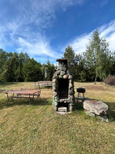 a picnic table and a stone oven in a park at Agroturystyka u Basi i Waldka in Zelwa