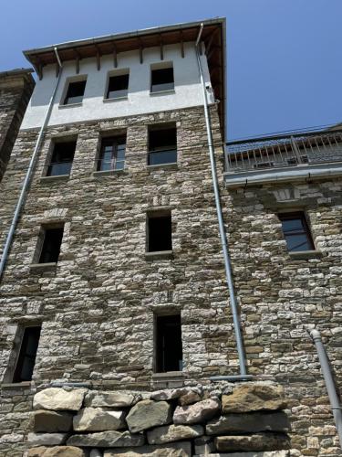 a tall stone building with windows on it at DAM Stone Boutique Hotel in Gjirokastër