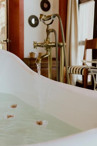 a bath tub with water pouring from a faucet at Hacienda San Nicolas de las Fuentes in Teuchitlán