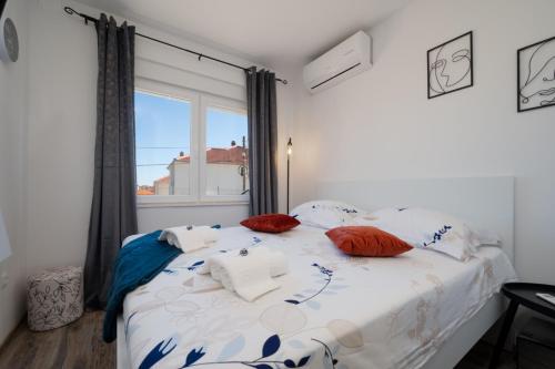 a bedroom with a bed with pillows and a window at Ante room's in Trogir