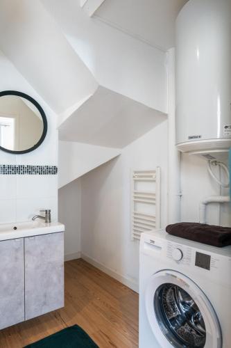 - une buanderie blanche avec un lave-linge et un lavabo dans l'établissement Studio cosy RDC, calme avec cour extérieure, à Saran