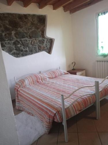 a bedroom with a bed and a stone wall at La Debbia Ranch in Vezzola