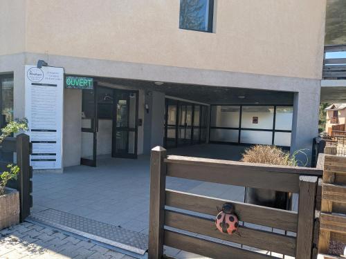 a front entrance to a building with a fence at Les Campanules du rivage in Embrun