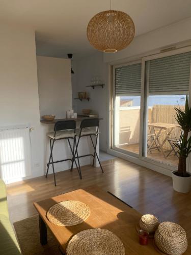 un salon avec une table et une cuisine dans l'établissement Appartement cosy sur Mennecy, à Mennecy