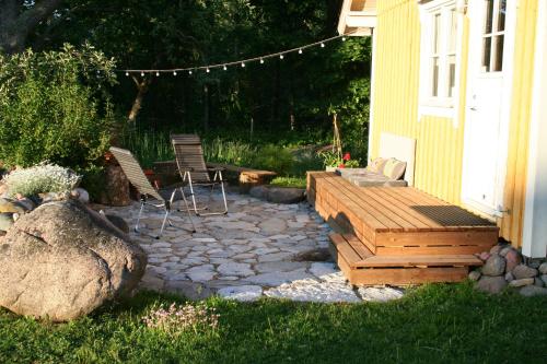 a patio with two chairs and a wooden deck at Türju rannamaja in Türju