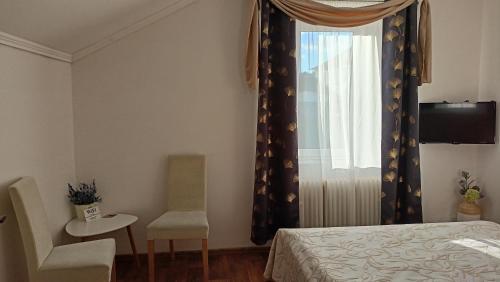 - une chambre avec un lit, une chaise et une fenêtre dans l'établissement Penzion Villa Marion, à Mariánské Lázně