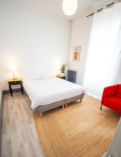 une chambre avec un lit et une chaise rouge dans l'établissement Villa Vichéia - Appartement 12, à Vichy