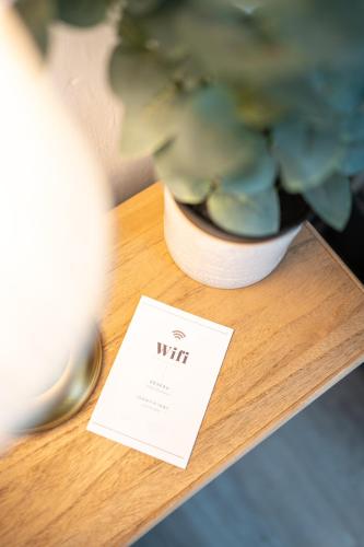 un vase avec une plante sur une table avec une carte dans l'établissement Villa Vichéia - Appartement 12, à Vichy