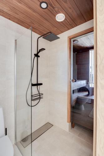 a shower with a glass door in a bathroom at Mainingin Loiste C2 - Luxury holiday in Kalajoki