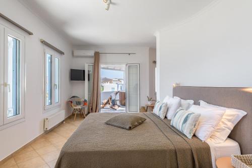 a bedroom with a large bed and a balcony at Villa Marisol in Pollonia
