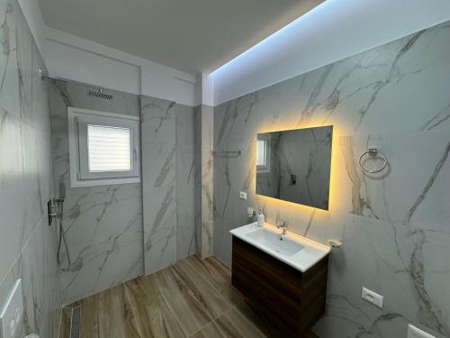 ein Badezimmer mit Waschbecken und Spiegel in der Unterkunft Babo's Villa in Vlorë
