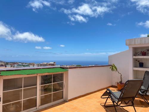 a balcony with two chairs and a view of the ocean at Ático La Laguna in Las Lagunas