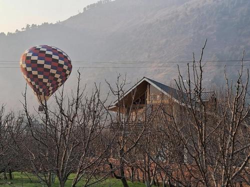 a hot air balloon is flying over a house at Skyview Cottages Manali in Manāli