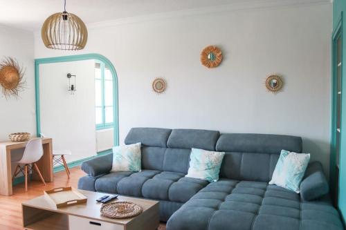 a living room with a blue couch and a table at Le Ptit Abri in Les Avenières