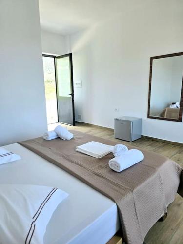 a white room with a bed with towels on it at Ambelas Getaways in Himare