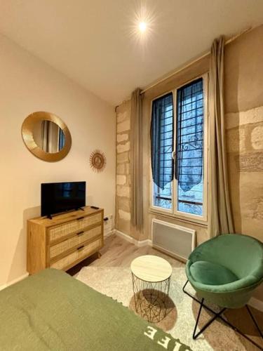 - une chambre avec une chaise verte et une télévision dans l'établissement Studio de charme Avignon centre, à Avignon