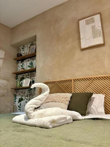 un cygne fait de serviettes sur un lit dans l'établissement Studio de charme Avignon centre, à Avignon