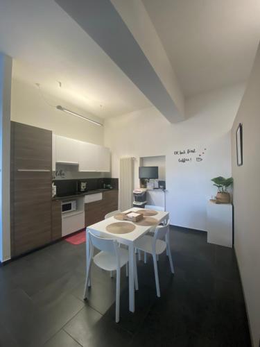 a kitchen with a white table and white chairs at *Love'n fly apartament * Airport- Ducati in Bologna