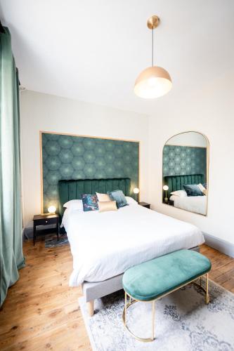 une chambre avec un grand lit et un grand miroir dans l'établissement Villa Vichéia - Appartement 24, à Vichy