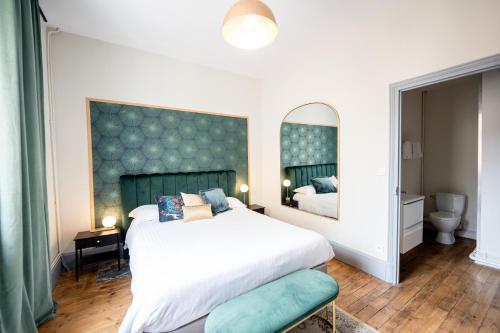 um quarto com uma cama grande e um espelho em Villa Vichéia - Appartement 24 em Vichy