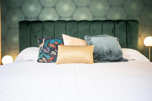 uma cama com quatro almofadas em cima em Villa Vichéia - Appartement 24 em Vichy