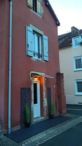 - un bâtiment en briques rouges avec une porte et une fenêtre dans l'établissement Charmante petite maison meublée, à Le Vernet