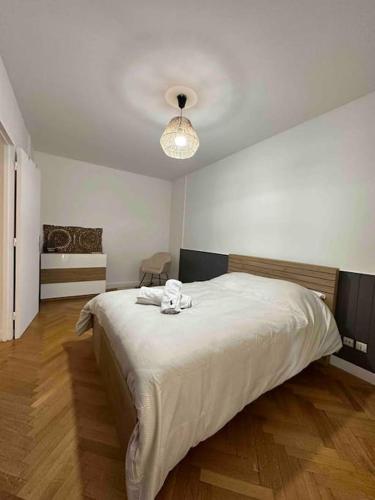 - une chambre avec un grand lit blanc et une lumière dans l'établissement Charmant t3 moderne avec garage, à Villeurbanne