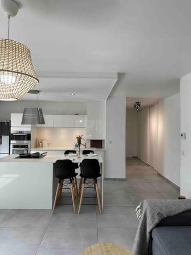 une cuisine avec une table et des chaises dans une pièce dans l'établissement Charmant t3 moderne avec garage, à Villeurbanne