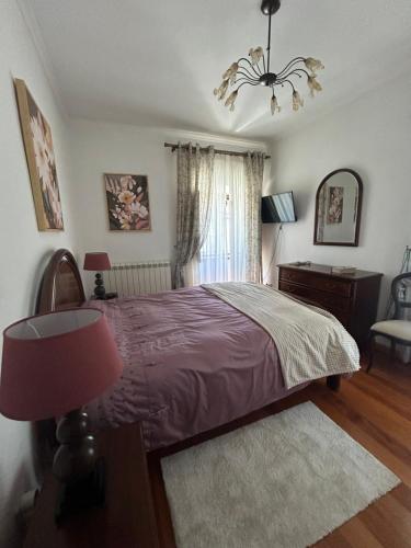 a bedroom with a bed and a lamp and a window at Casa Portas da Cruz in Almeida
