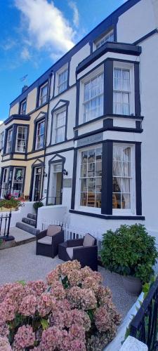 a blue and white building with flowers in front of it at Beach Cove in Llandudno
